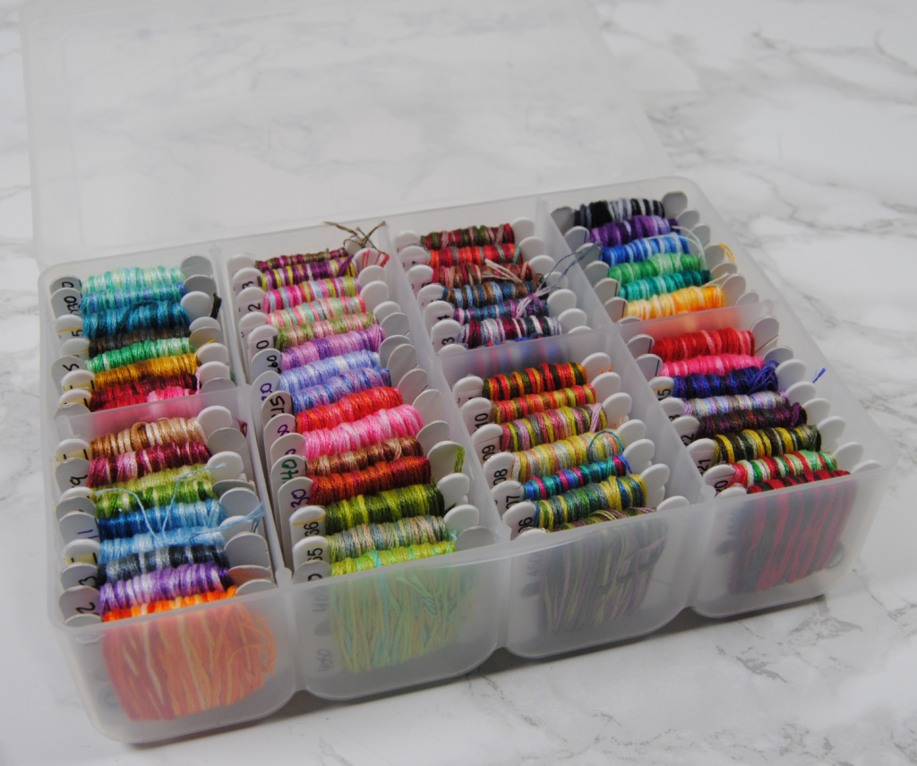 A miniature thread box full of DMC variegated thread.
