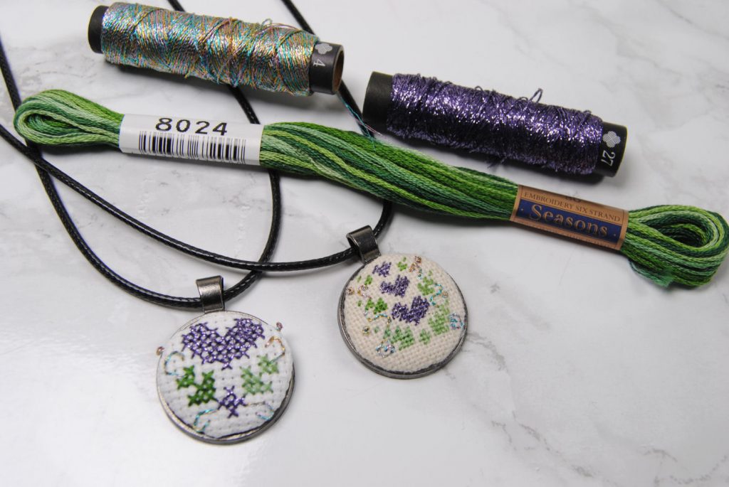 Finished cross stitch and petite point pendants using Lecien Cosmo Seasons and Nishikiito threads.