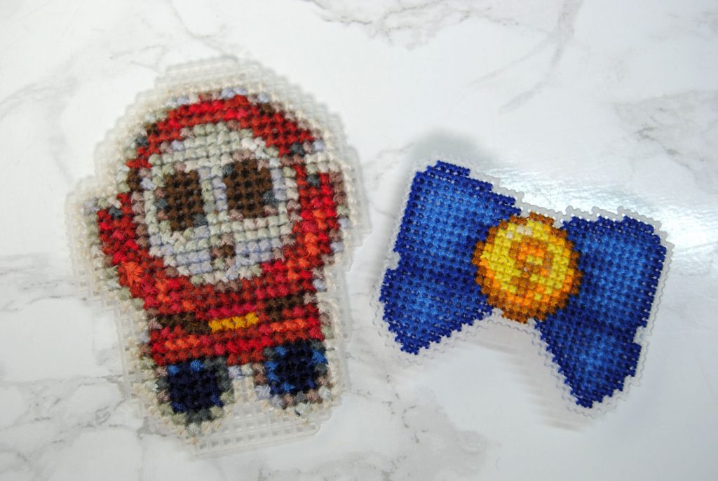 Two cross stitches on plastic canvas. One in 10 count, one in 14 count.