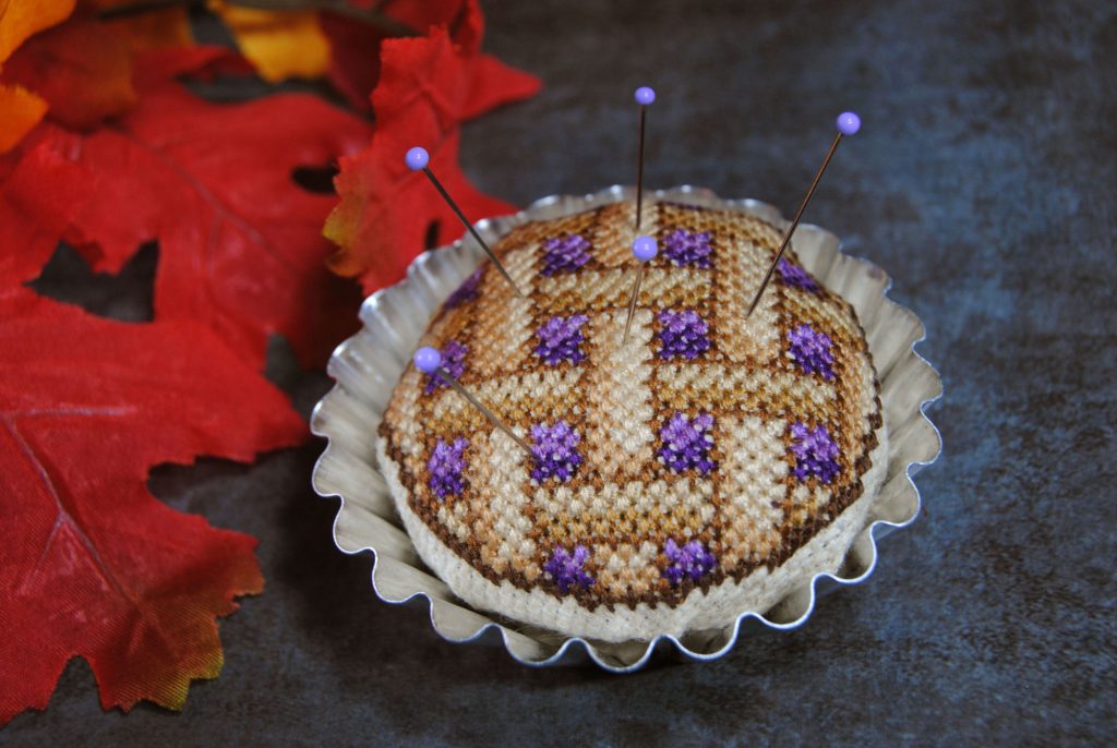 A pin cushion in the shape of a blueberry pie.