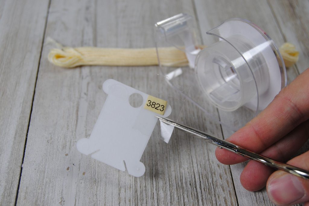 Cutting tape to adhere a label onto a plastic bobbin