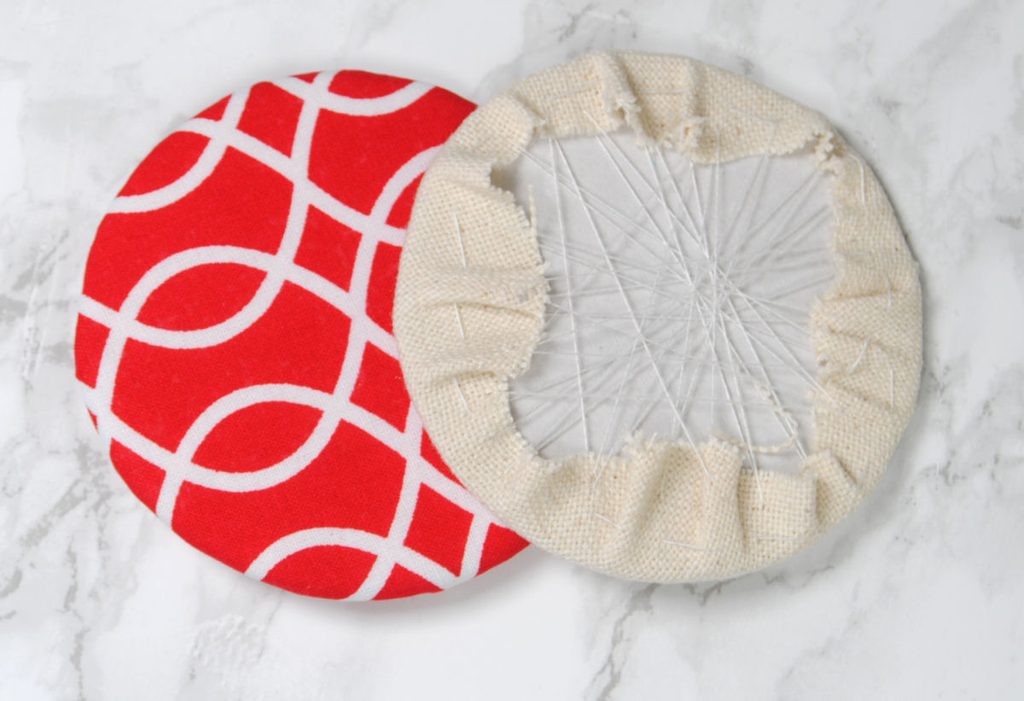 Two fabric wrapped cardboard discs ready to be assembled into a round ornament.