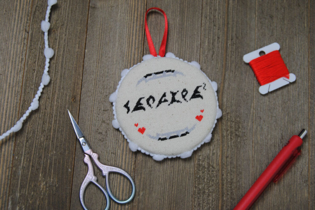 A Klingon themed cross stitch finished as a flat ornament.