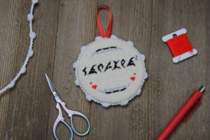 A Klingon themed cross stitch finished as a flat ornament.