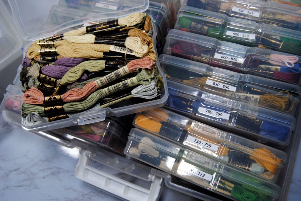 A large plastic box full of smaller photo boxes each full of embroidery thread skeins and labeled