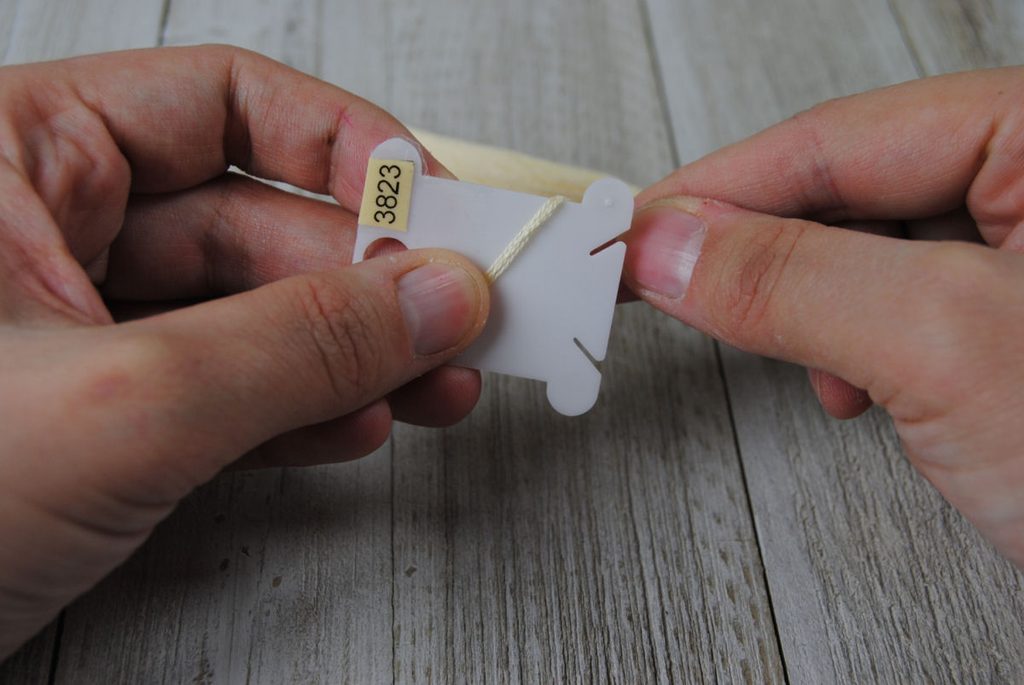 Embroidery thread beginning to be wound on a plastic bobbin