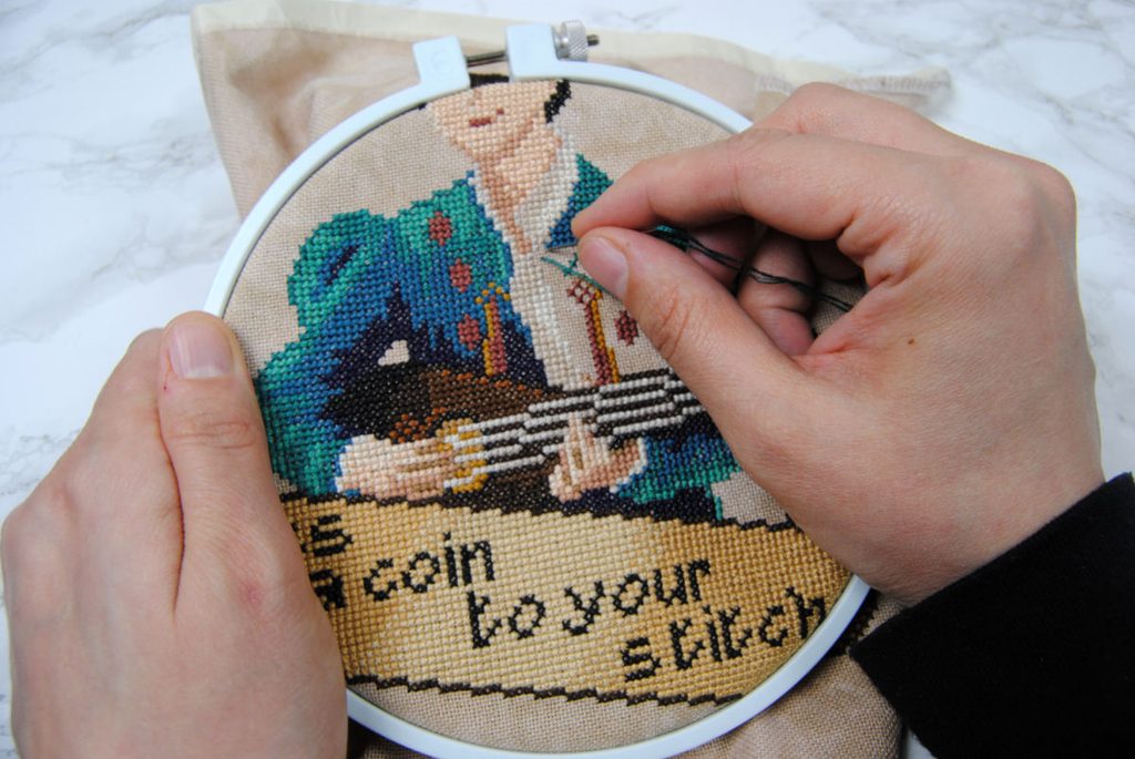 Demonstration of cross stitching in an embroidery hoop.