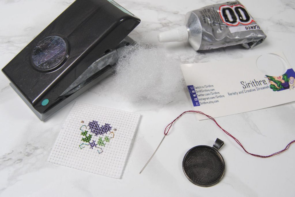 Materials for making a cross stitch pendant necklace.