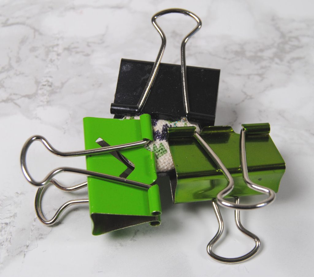 Demonstration of using binder clips to hold pendant tray while glue dries.
