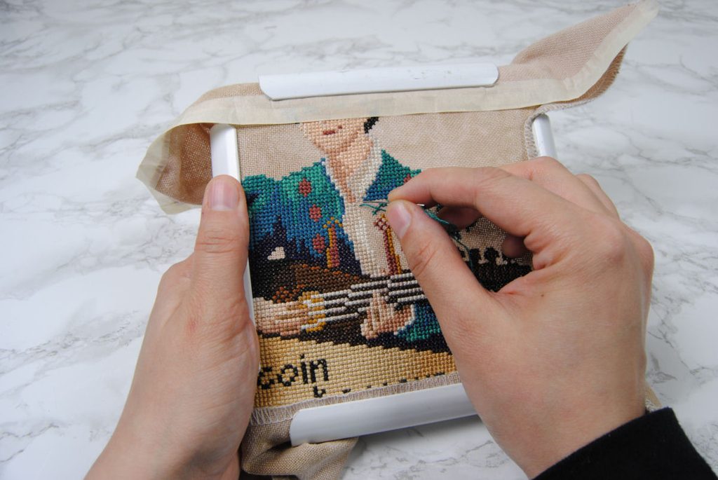 Demonstration of cross stitching in a Q-snap snap frame.