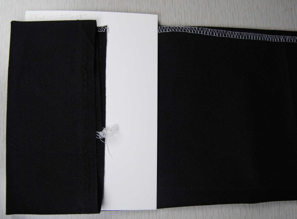 Demonstration of wrapping fabric around a comic book board bolt.