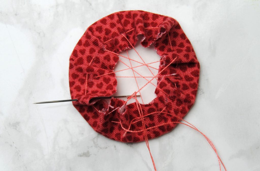Stitch across the fabric circle to tighten it in place. 