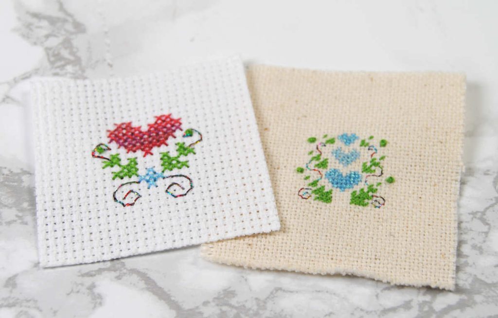 Two cross stitches of hearts and leaves done in Sulky brand thread.