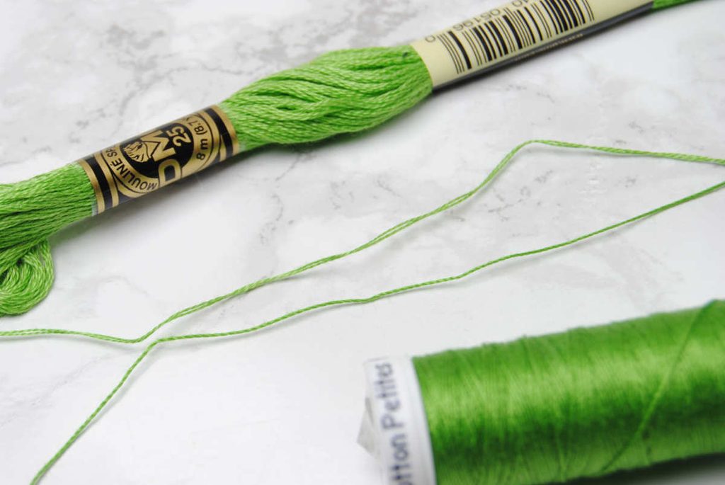Comparison of 2 strands DMC embroidery thread and a spool of Sulky Petites.