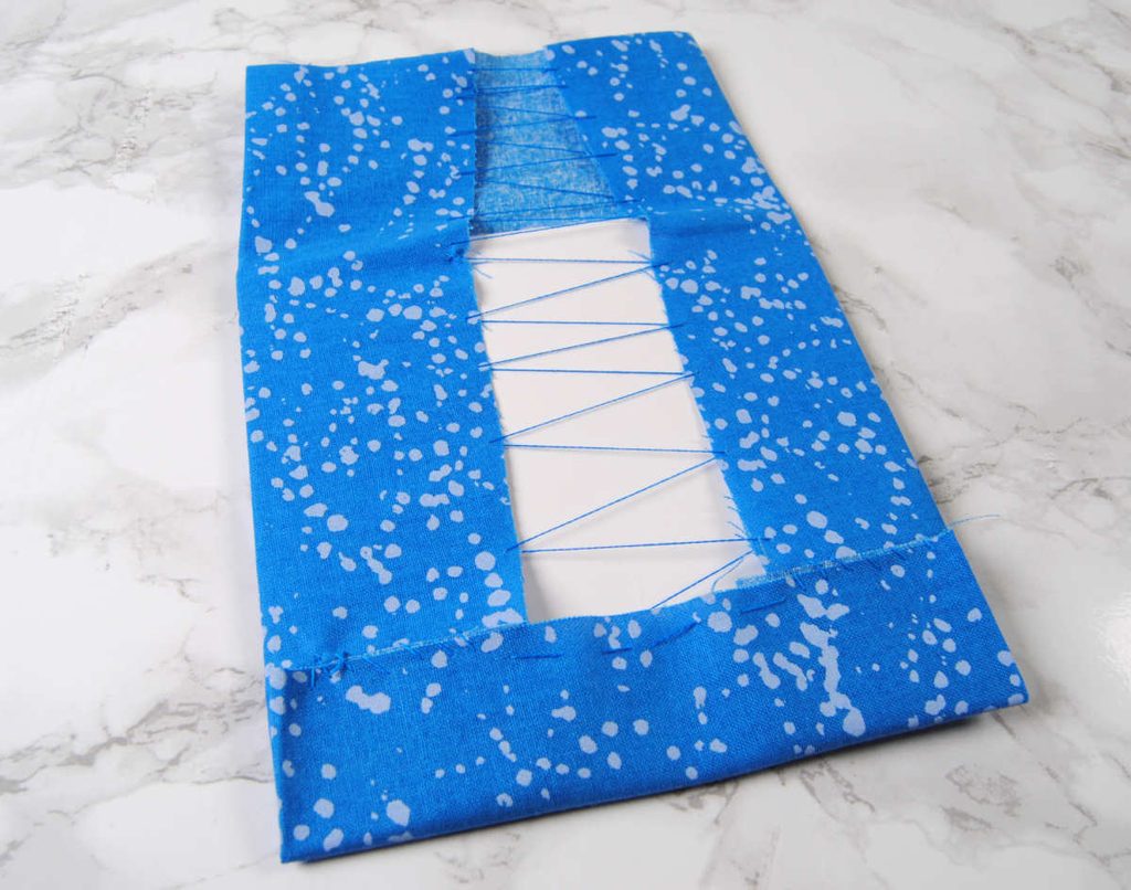 Fabric sewn around a cardstock square, leaving a one side loose to work as a flap for our flatfold.