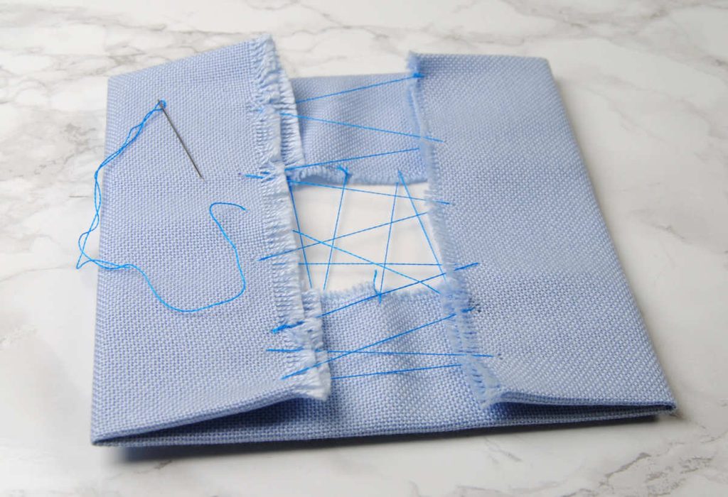 Fabric folded over a cardstock square, stitched together.
