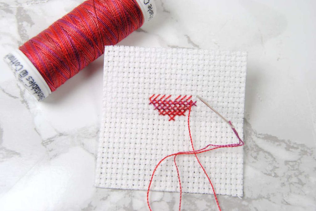A partially stitched cross stitch heart done in Sulky Blendables thread.