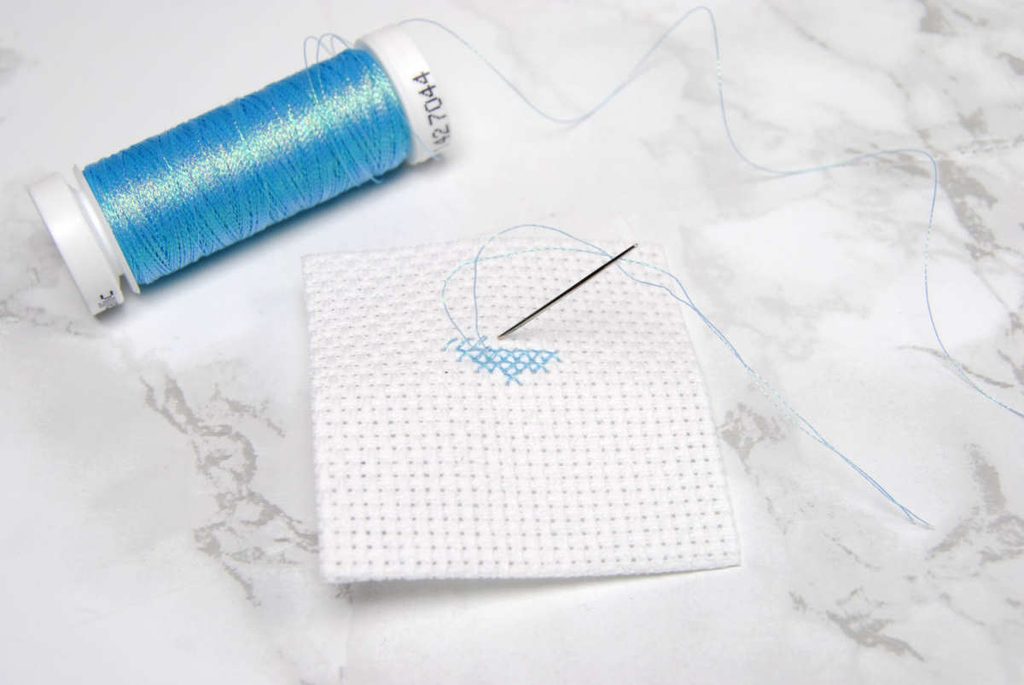 A partially stitched cross stitch heart done in Sulky Metallics.