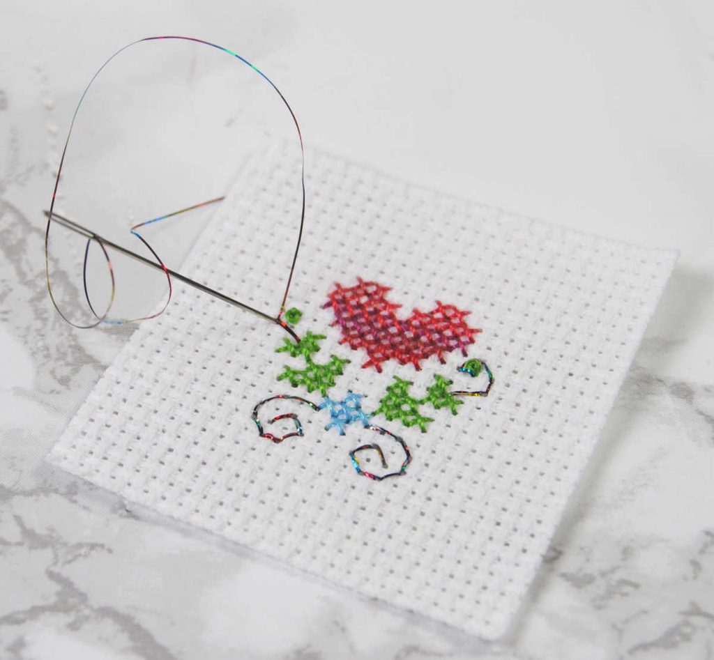 Backstitch with two strands Sulky holoshimmer on 14 count aida.