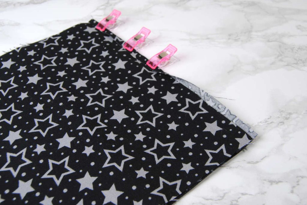 Rolling over and clipping edges in place to sew down.
