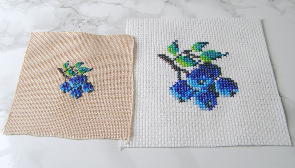 The same bluberry pattern done in two different styles. Cross stitch and petit point