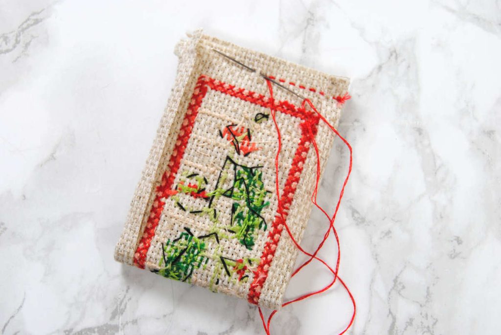 A running stitch along aida edges to sew two ends together.