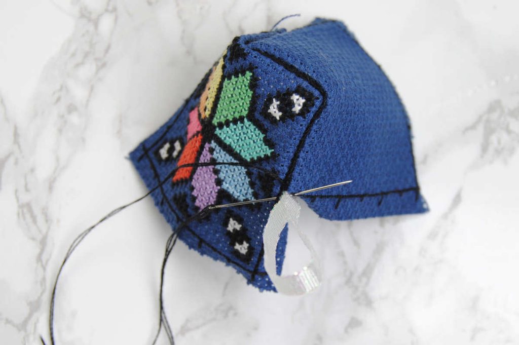 Demonstrating sewing a ribbon into the edges of your biscornu.