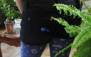 Stardew Valley blue chickens cross stitched onto shorts pockets using waste canvas.