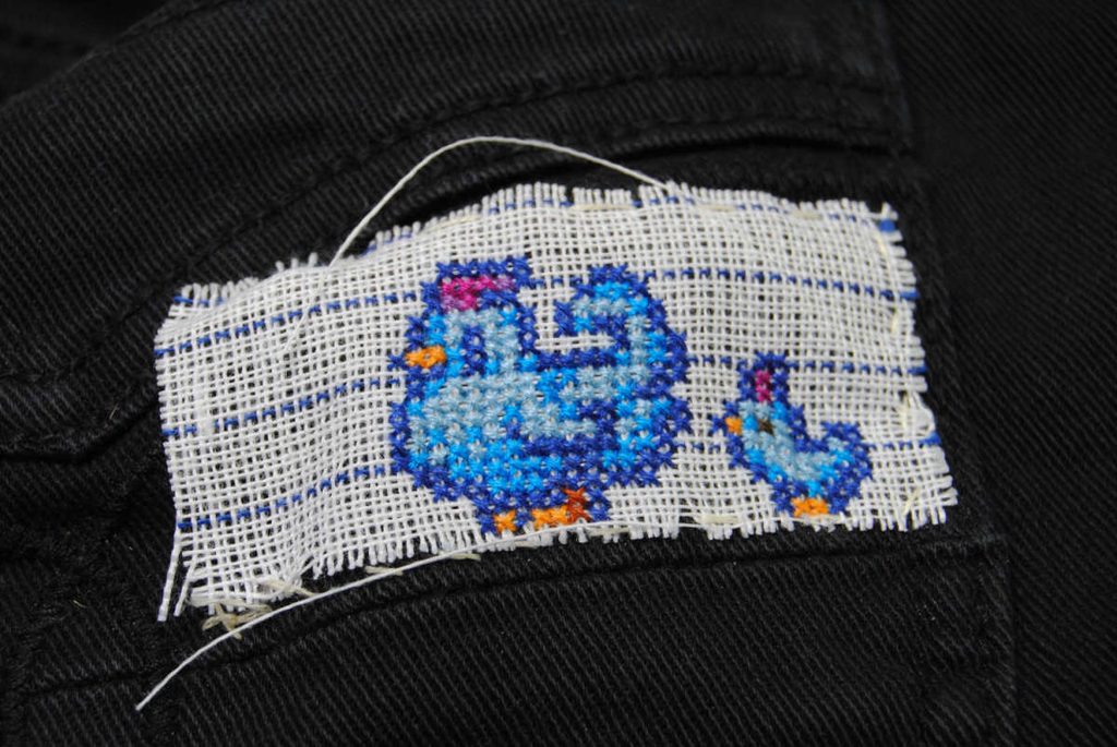 Finished Stardew chickens cross stitch prior to removing waste canvas.