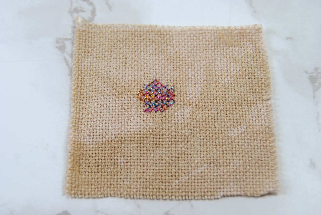 Cross stitch lotus flower in accentuate metallic thread.