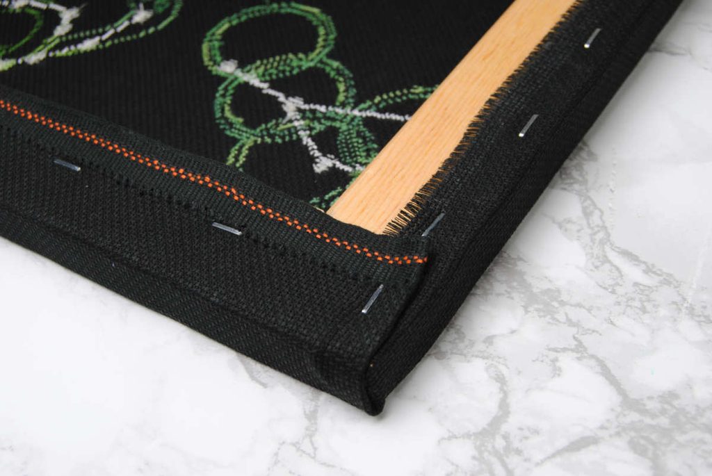 A neatly tucked fabric corner stapled down to secure it in place.