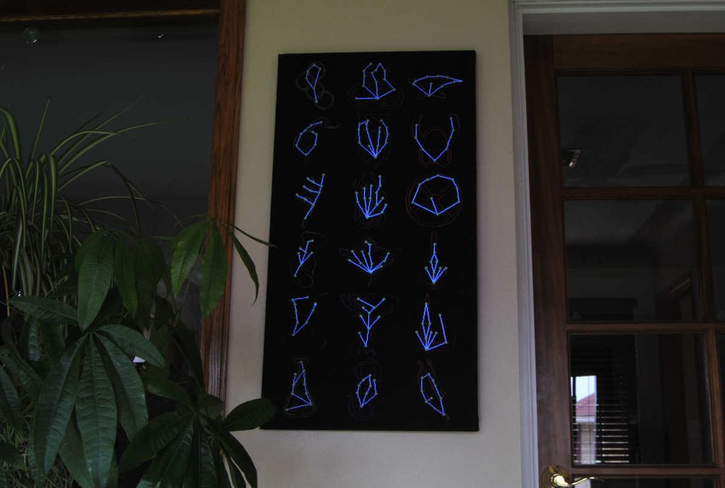 Cross stitch of the Skyrim skill constellations with lights off showing that the stars glow in the dark.