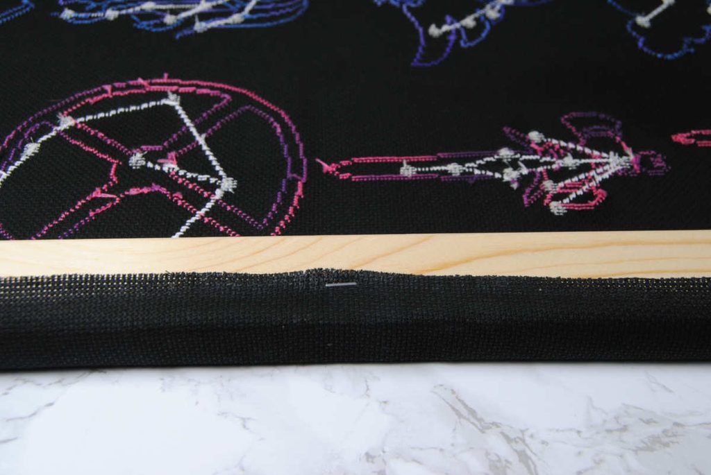 Stapling down the first side of fabric, halfway down the longest side.
