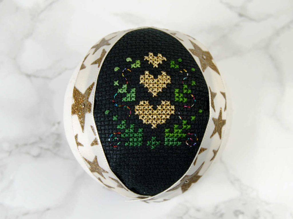 Close up of the finished cross stitc fabric ornament before adding ribbon.