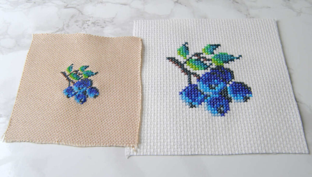 Comparing the same blueberry pattern done in both cross stitch and petit point.
