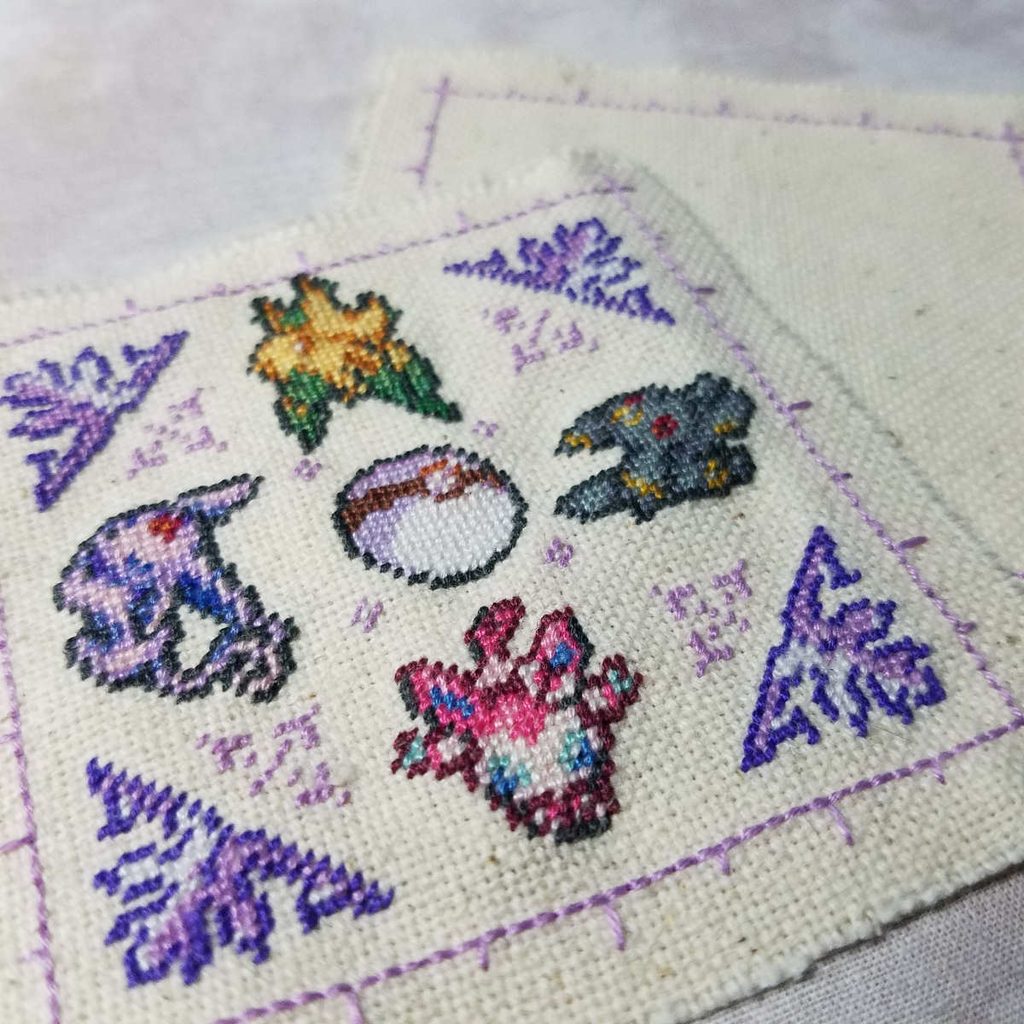 Closeup of Pokemon Eeveelutions biscornu done in petit point pre-assembly.