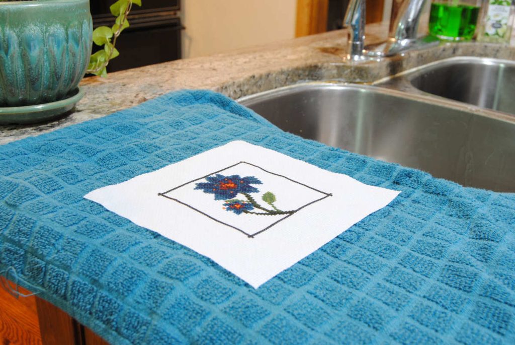 A freshly washed cross stitch air drying on a towel