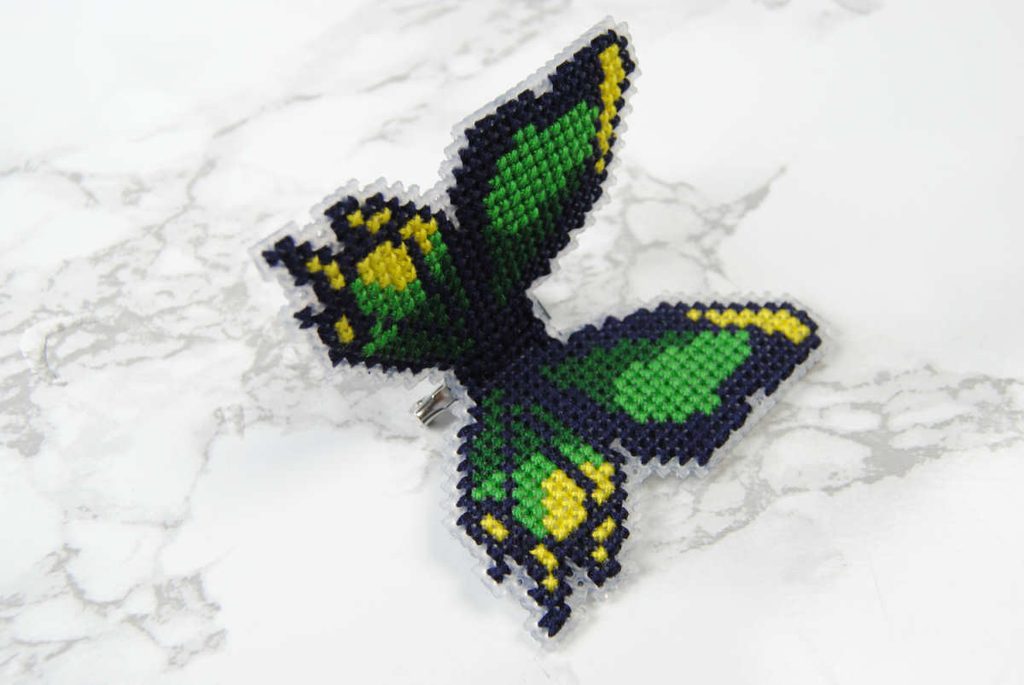 Overview shot of the finished cross stitch butterfly pin.