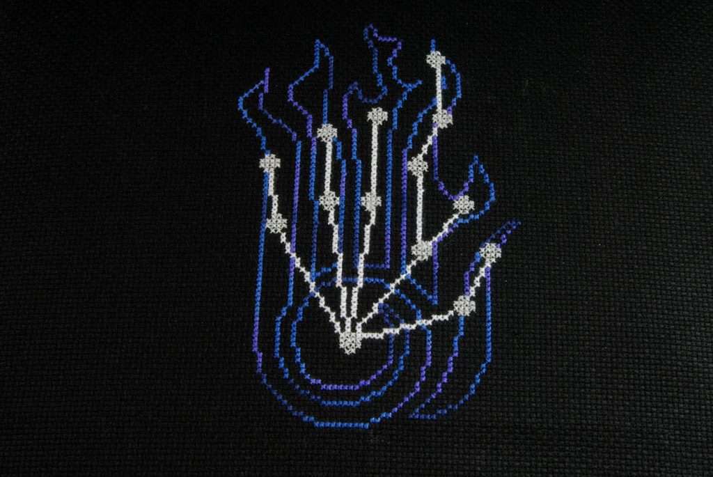 A cross stitch of the Skyrim Destruction skill constellation with the stars in glow in the dark thread.
