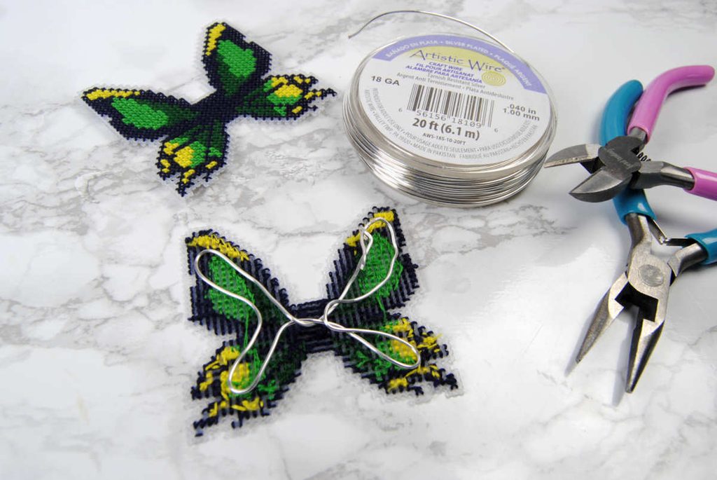 Demonstrating how to bend wire in the vague shape of a butterfly