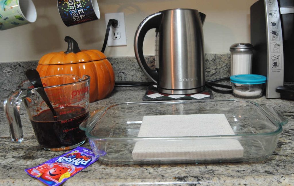 Preparing the Kool-aid by adding water and vinegar.