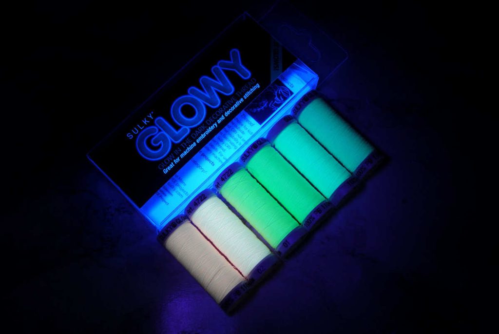 Sulky Glowy brand thread spools glowing in the dark under a blacklight