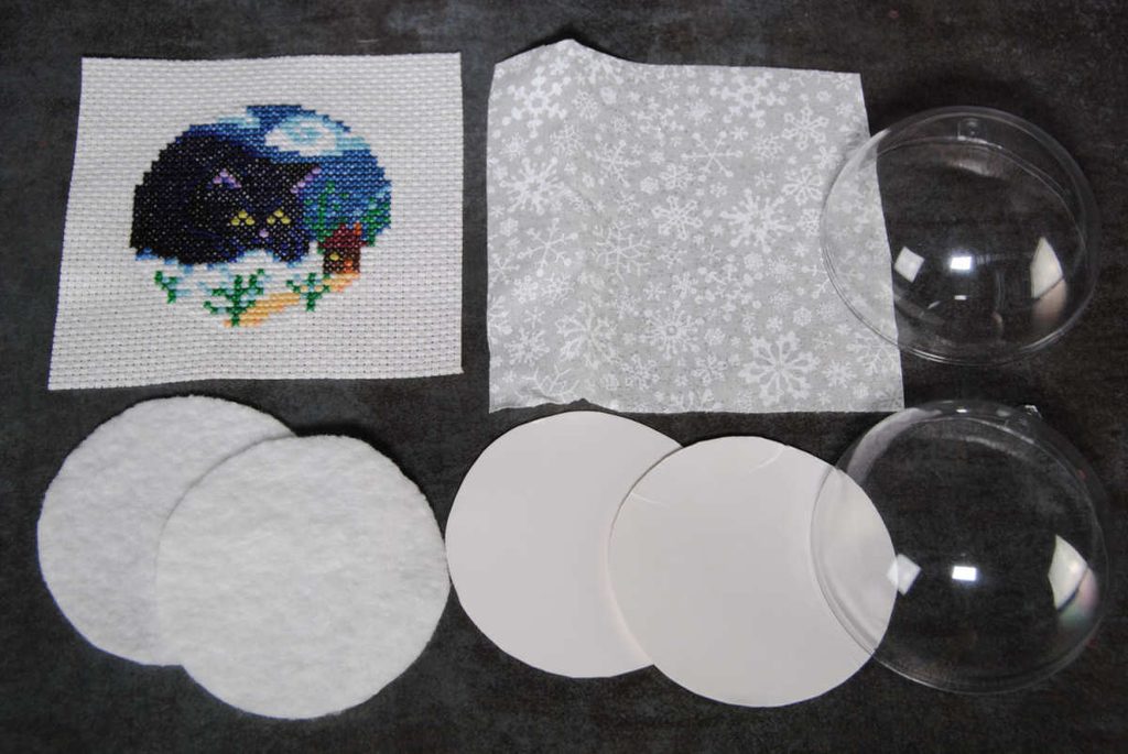 Prepared materials for a cross stitch snowglobe ornament
