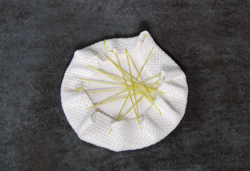 Lacing fabric around a cardstock circle.