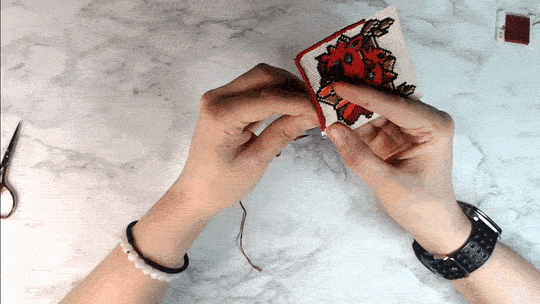 Hand sewing border around a cross stitch patch