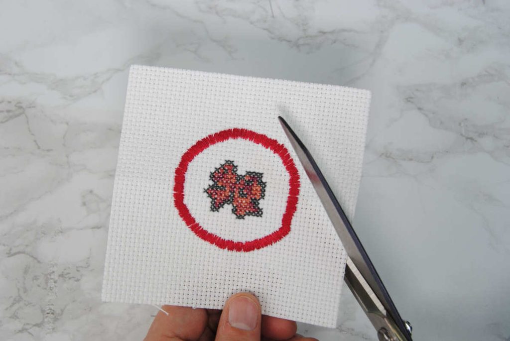 Cutting out the cross stitch patch.