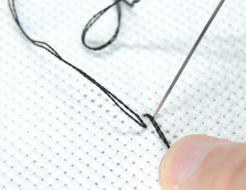 Continue your first cross stitch, being careful to stitch over the tail of your thread.
