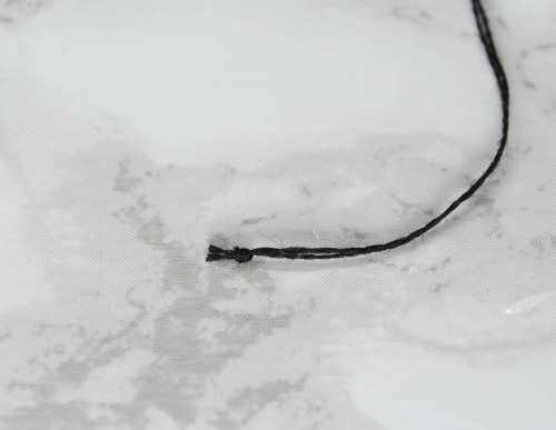 Example of a thin thread knot, trimmed close.