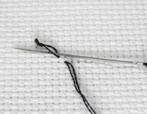 Feed your needle through the loop created by the knot on the back.