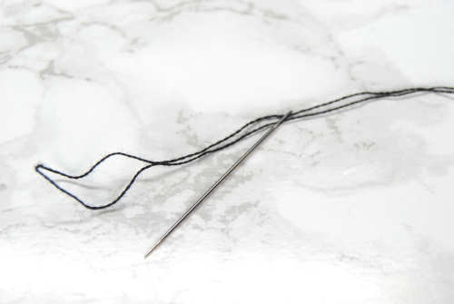 Fold over a single strand of thread and thread the loop through your needle.